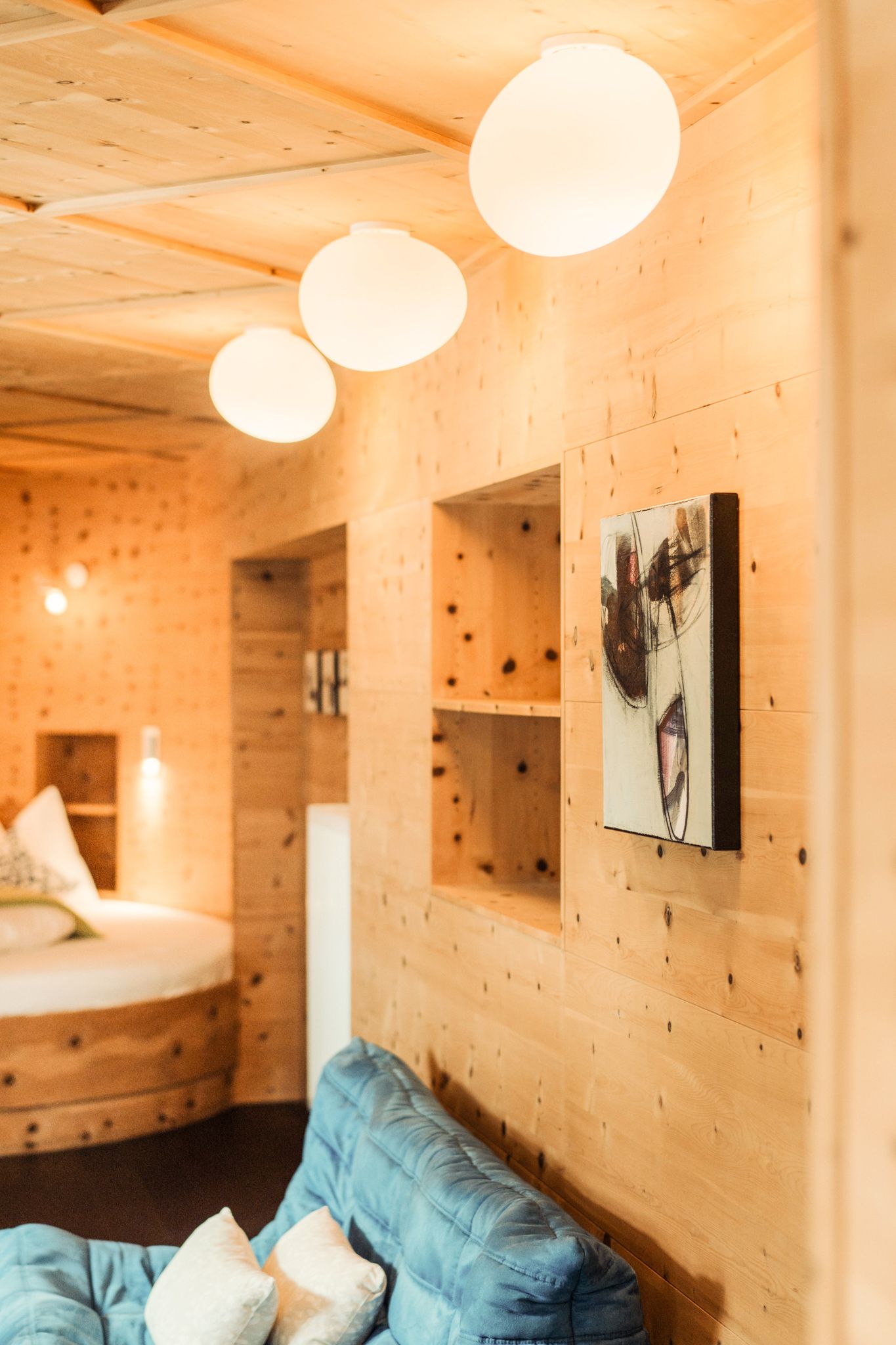 Gemütlicher Raum im Glemmtalerhof in Hinterglemm mit Holzverkleidung und modernen Lampen.