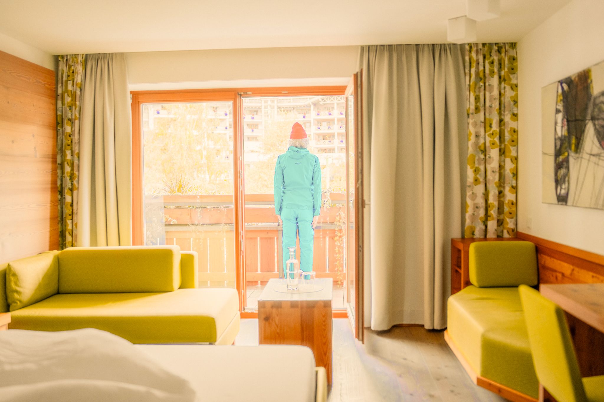 Ein Mann in Winterkleidung steht am Balkon des Glemmtalerhofs in Hinterglemm.