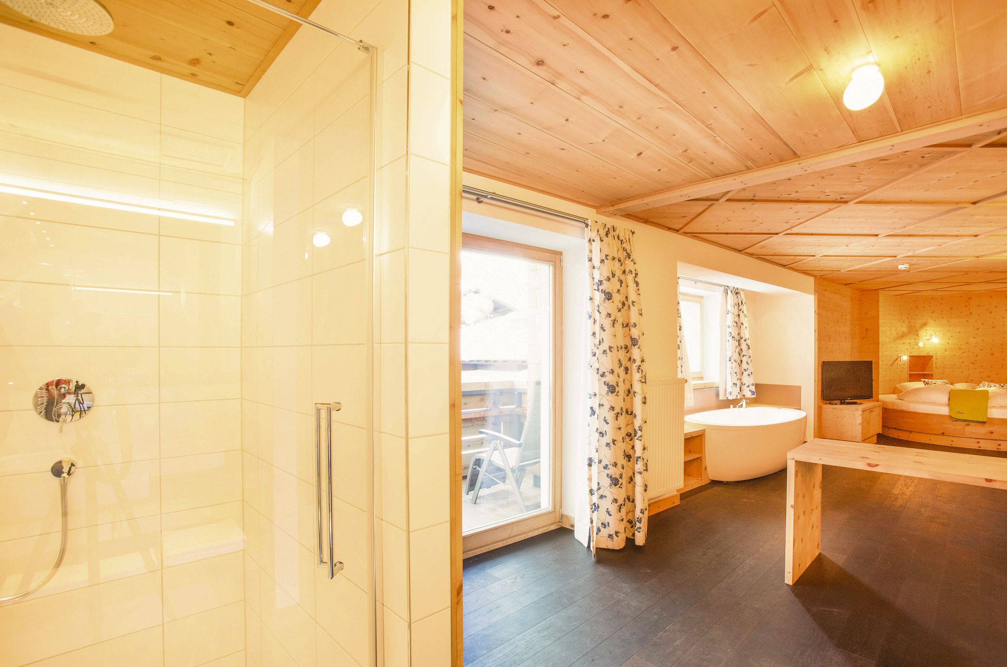 Ein modernes Zimmer im Glemmtalerhof mit Dusche, Badewanne und Balkonblick in Hinterglemm.