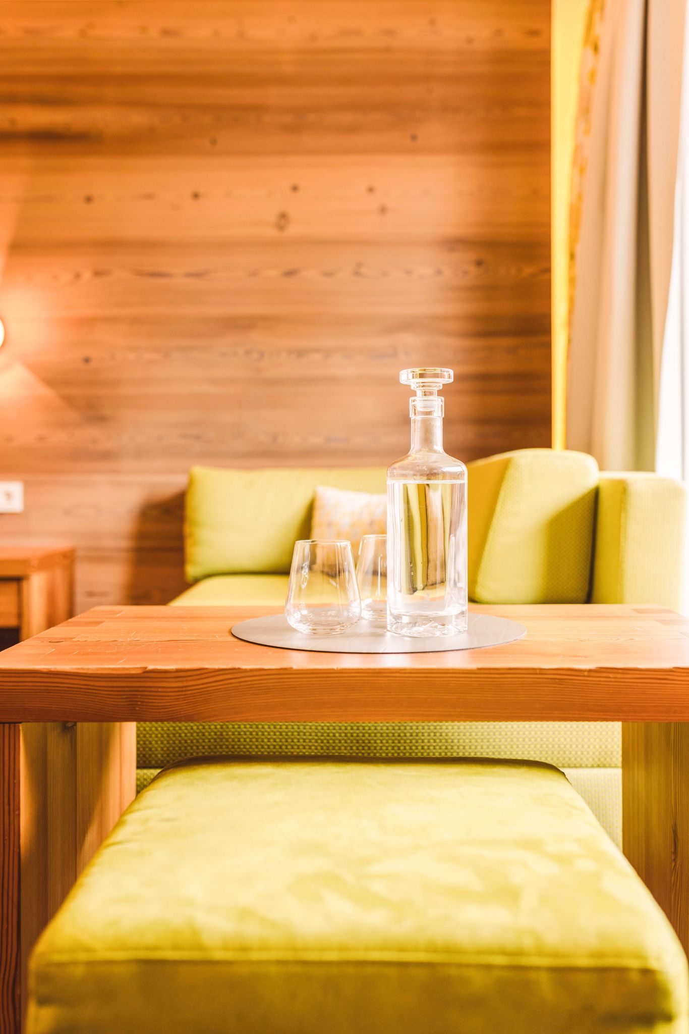 Ein gemütlicher Tisch mit Gläsern und einer Karaffe im Glemmtalerhof in Hinterglemm.