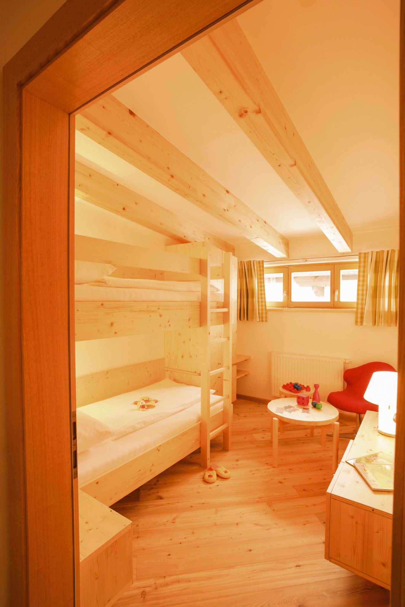 Helles Kinderzimmer im Glemmtalerhof mit Etagenbett und Spielzeug. Gemütlicher Holzstil für Familienurlaub.