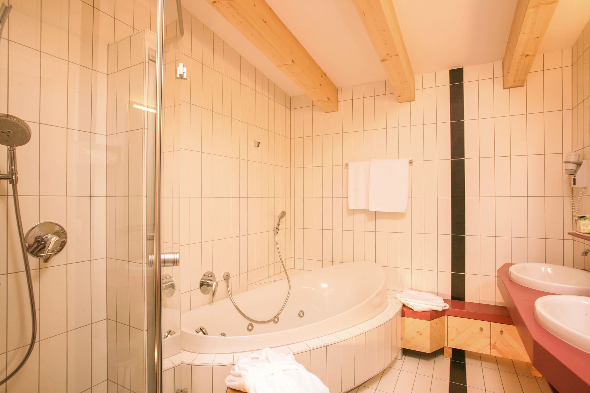 Elegantes Badezimmer im Glemmtalerhof mit Whirlpool und modernen Armaturen.