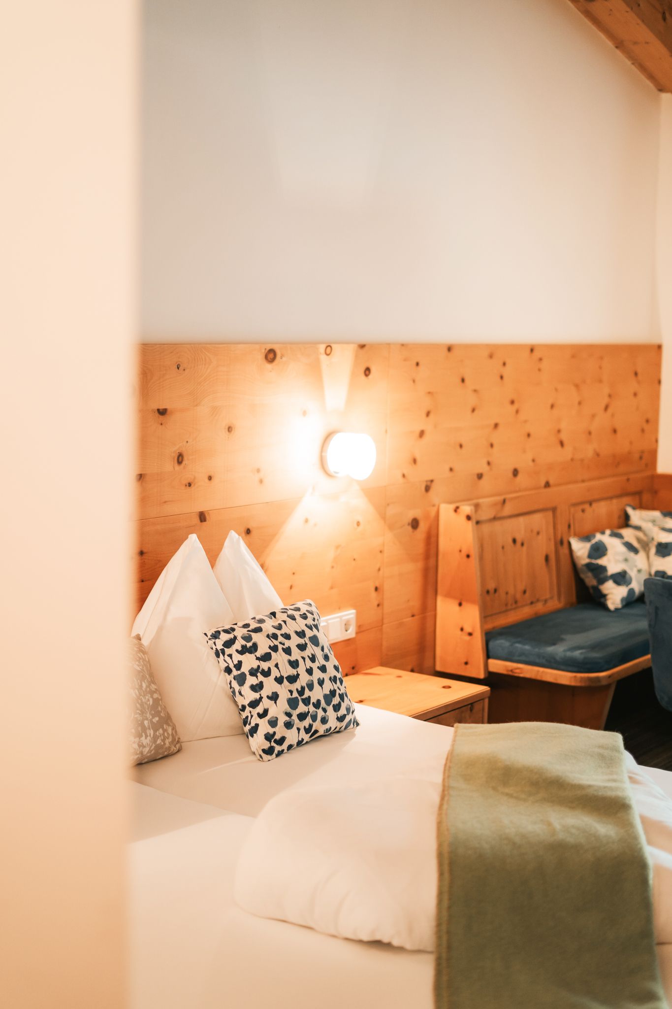 Ein gemütliches Zimmer im Glemmtalerhof in Hinterglemm mit Holzdekor und stimmungsvollem Licht.