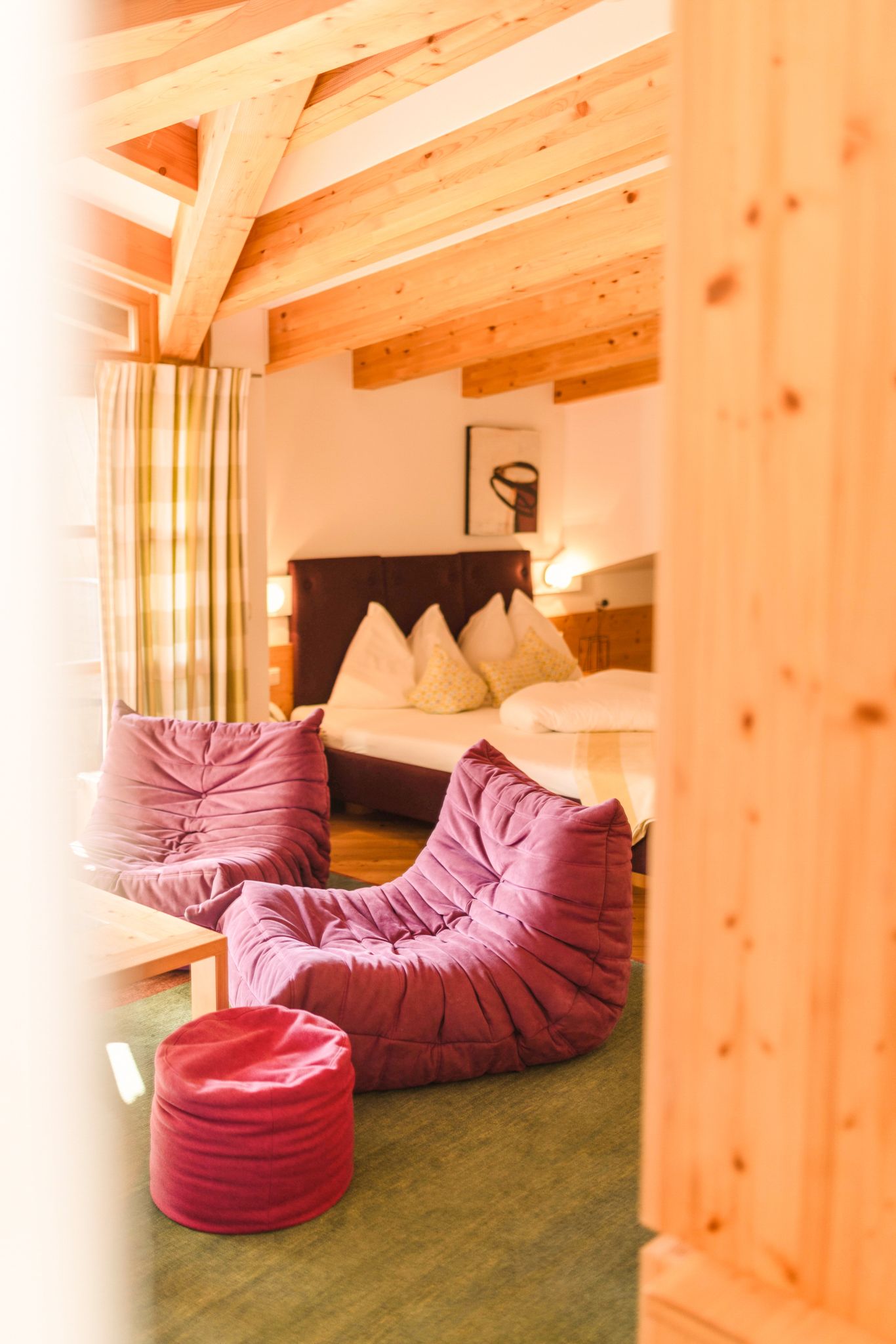 Gemütliches Zimmer im Glemmtalerhof mit Holzdecke und lila Möbeln.